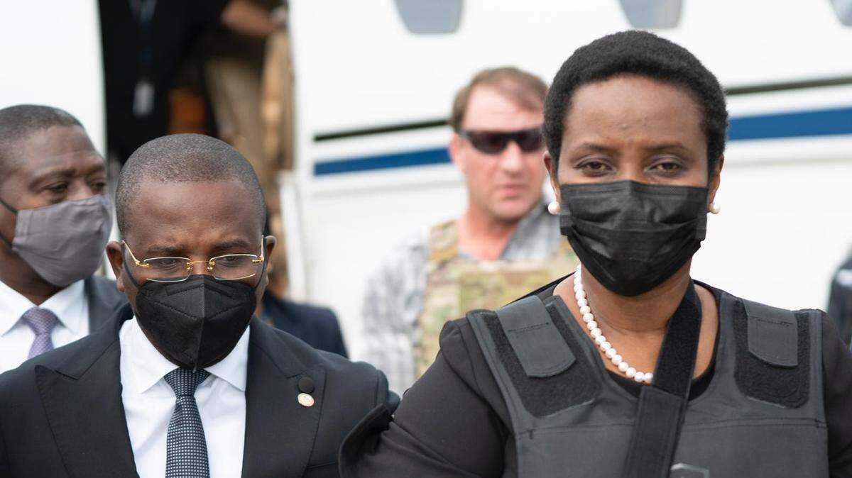 El primer ministro en funciones de Haití Claude Joseph escolta a Martine Moïse, primera dama de Haití, a su regreso al país el 17 de julio de 2021, desde Miami, tras el asesinato de su esposo.