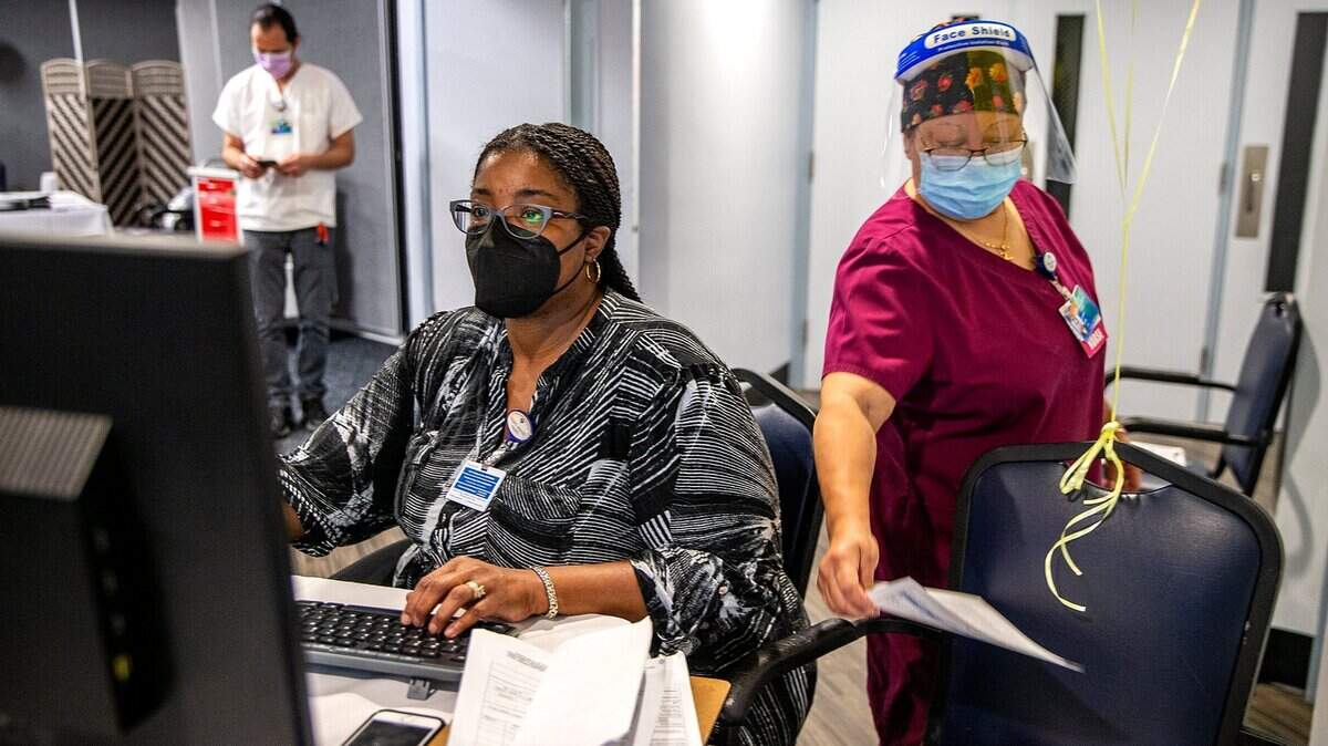 Lantaya Chayten (izquierda),  coordinadora de pacientes externos, y la enfermera Lynnette Lee, inscriben a algunos empleados que se estaban vacunando contra el COVID-19 en el Miami Jewish Healthel 19 de agosto de 2021.