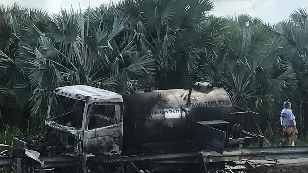 A charred septic truck is parked after crashing into a guardrail along a canal on Southwest 248th Street in Princeton, Florida, Wednesday, Aug. 12, 2020.