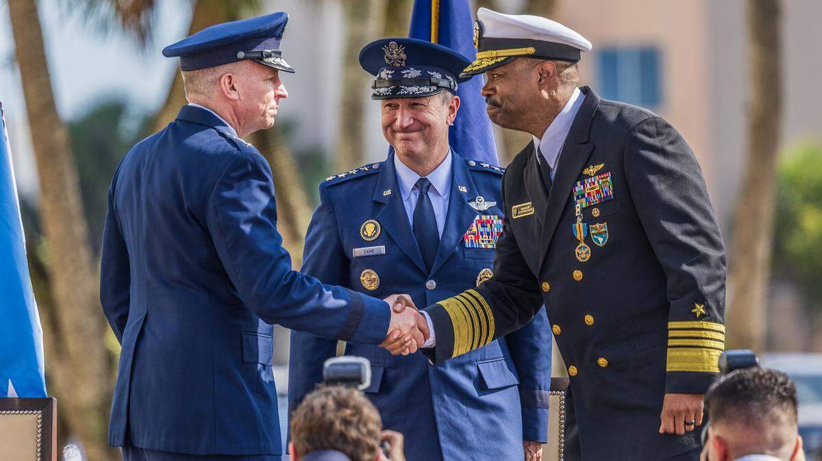 Air Force Gen. Dan Caine (center), Chairman of the Joint Chiefs of Staff, looks on as Air Force Lt. Gen. Evan L. Pettus (far left) and Navy Adm. Alvin Holsey shake hands as the Navy Adm. relinquishes his duties as commander of U.S. Southern Command (SOUTHCOM), to the Lt. Gen. Pettus, during a ceremony at the command’s headquarters in Doral, on Friday, December 12, 2025. 