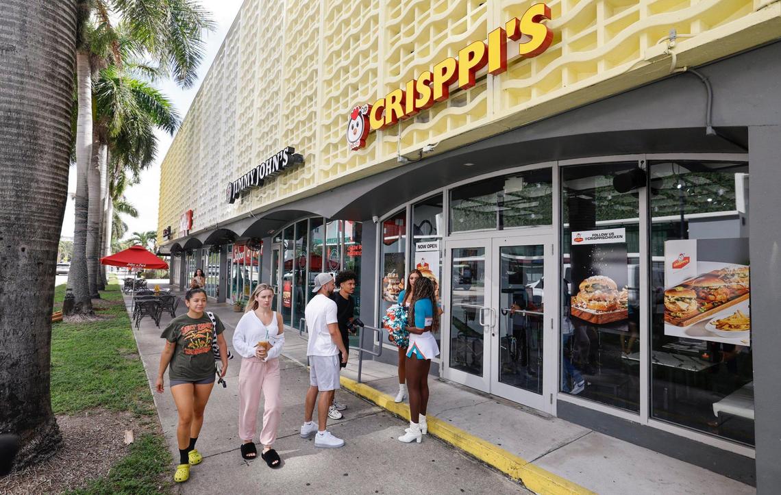 Miami Dolphins cheerleaders greet customers as they arrive at NFL football Hall of Famer Randy Moss’ Crisppi’s Chicken franchise on Friday, July 11, 2025.