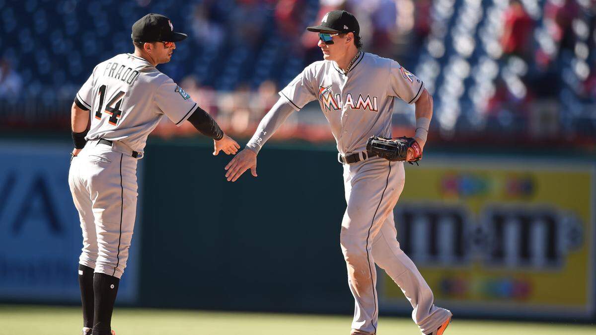 WASHINGTON, DC - JULY 08:  Derek Dietrich #32 of the Miami Marlins celebrates a win with Martin Prado #14 after a baseball game against the Washington Nationals at Nationals Park on July 8, 2018 in Washington, DC.  (Photo by Mitchell Layton/Getty Images)