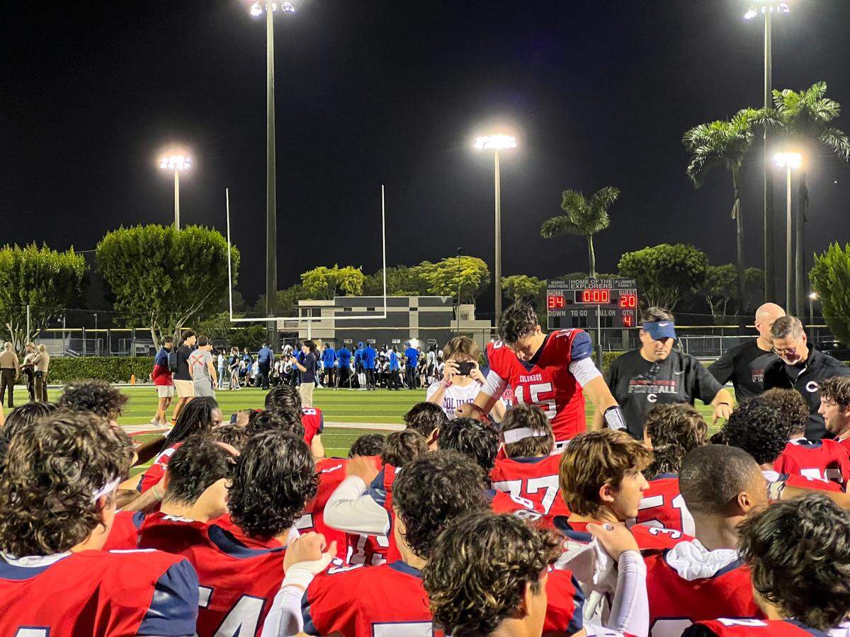 Columbus quarterback Alberto Mendoza leads the team in prayer after Friday night’s win over South Dade in a Region 4-4M semifinal at Columbus.