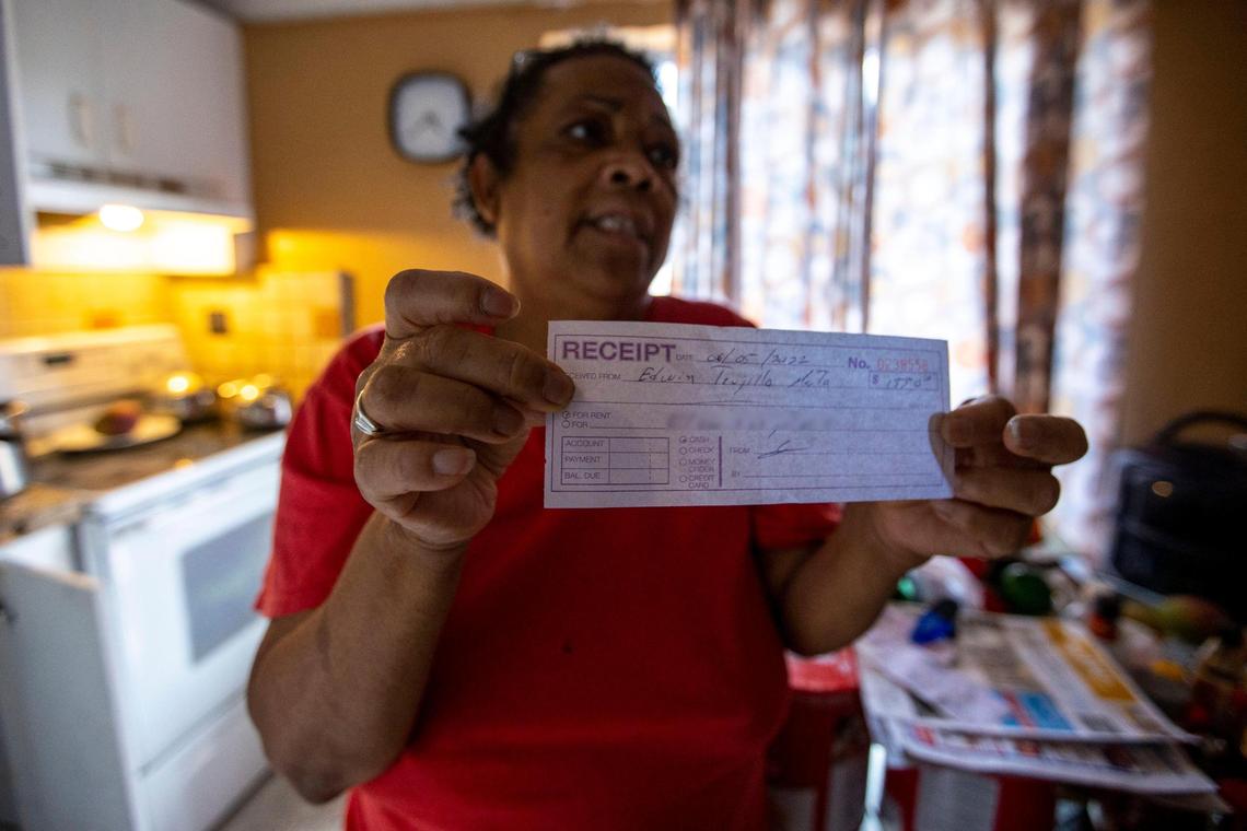 Renter Nora Trujillo, 62, holds up a check showing the $1,500 being charged by the landlord for rent despite the owner rejecting a request to make repairs for damage caused by flooding a week earlier, in the Little Havana neighborhood of Miami, Florida, on Friday, June 10, 2022.
