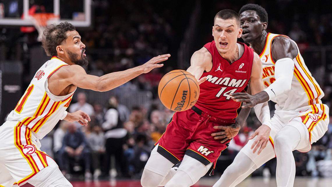 Miami Heat guard Tyler Herro (14) loses the ball between Atlanta Hawks guard Trae Young (11) and forward Mouhamed Gueye (18) during the first half at State Farm Arena.