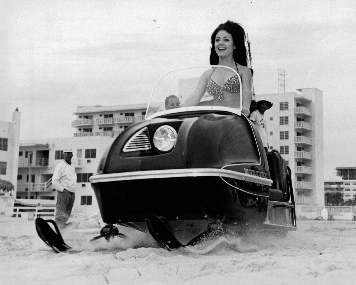 Miami model Nilda Rice roars down the beach a driving snowmobile. It was a gimmick to promodte the forthcoming Miami International Boat Show.