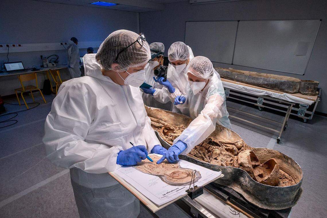 Researchers studying the coffin.