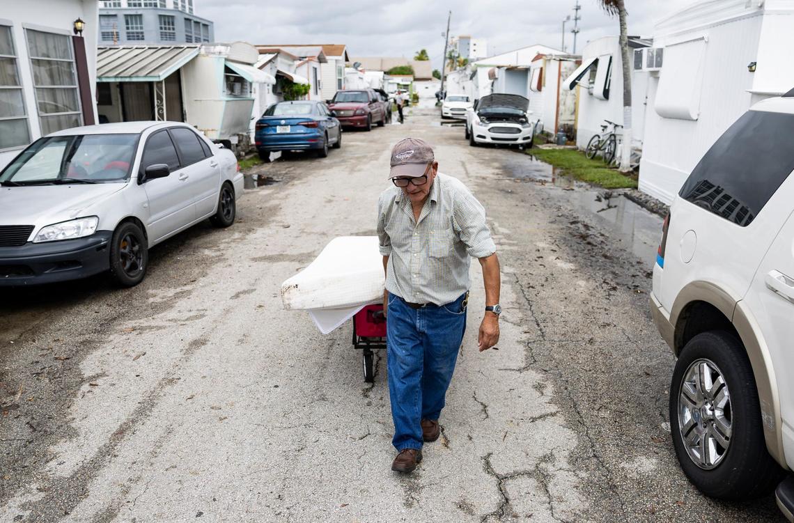 Manuel Sarmiento, 78, who lives at Royal Palm Mobile Home Park, wheels a wet mattress down his neighborhood after his community was flooded on Thursday, June 13, 2024, in Hallandale Beach, Florida. Residents at the mobile home park are dealing with the aftermath of Wednesday’s storm that left their community flooded.