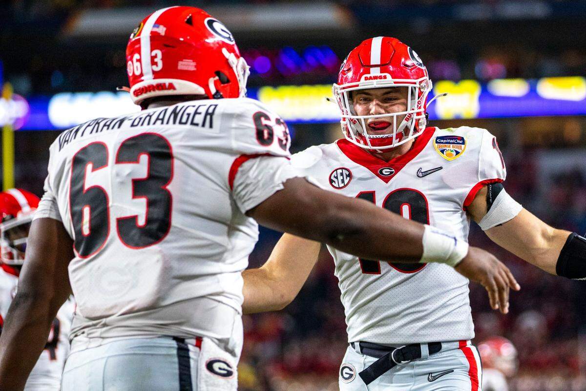 University of Georgia tight end Brock Bowers (19) celebrates with teammate offensive lineman Sedrick Van Pran- Granger (63) after scoring a touchdown against University of Michigan during the first quarter of the 2021 College Football Playoff Semifinal at the Capital One Orange Bowl hosted at Hard Rock Stadium in Miami Gardens, Florida, on Friday, December 31, 2021.
