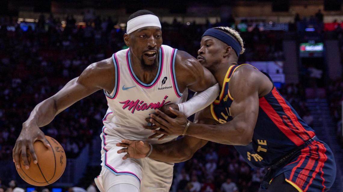 Miami Heat center Bam Adebayo (13) drives on Golden State Warriors forward Jimmy Butler III (10) during the second half of an NBA game at Kaseya Center on March 25, 2025, in Miami.