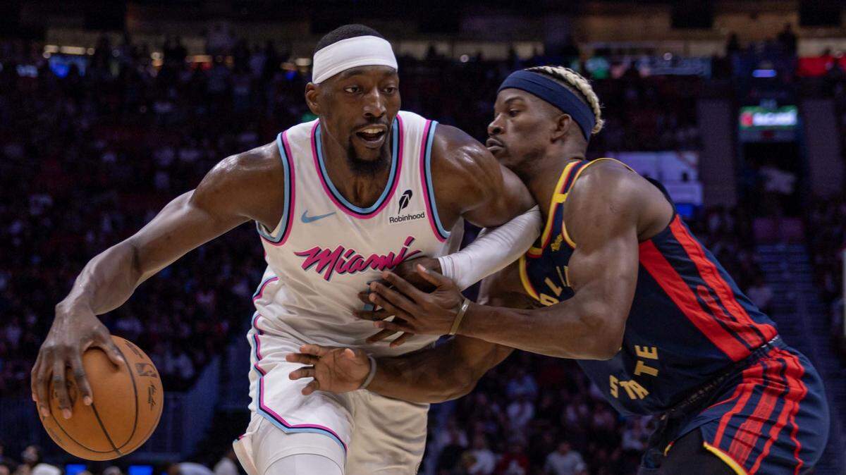 Miami Heat center Bam Adebayo (13) drives on Golden State Warriors forward Jimmy Butler III (10) during the second half of an NBA game at Kaseya Center on March 25, 2025, in Miami.