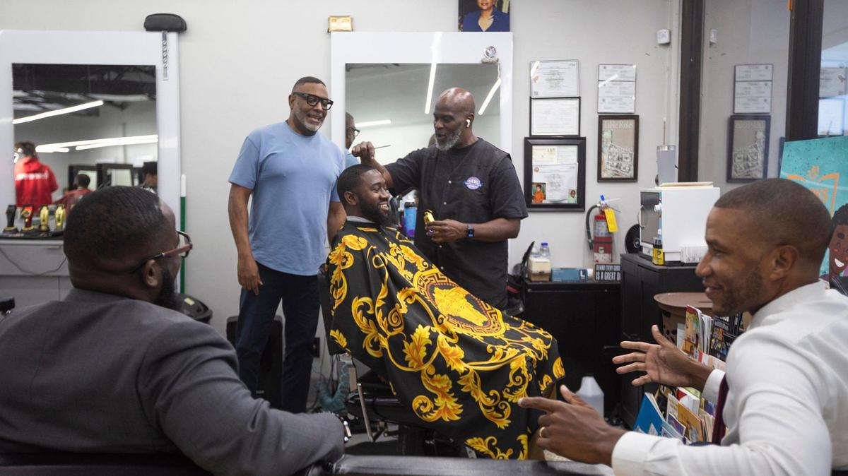 (Back, left to right) Ruban Roberts with Jefferson Noel, Founder of Barbershop Speaks and barber Michael Stephens at Topcuttaz barbershop in Miami Gardens. In the front are Ezra Dieuveille (left) and Marcus Bright. The men came together at the barbershop to discuss the upcoming presidential election.