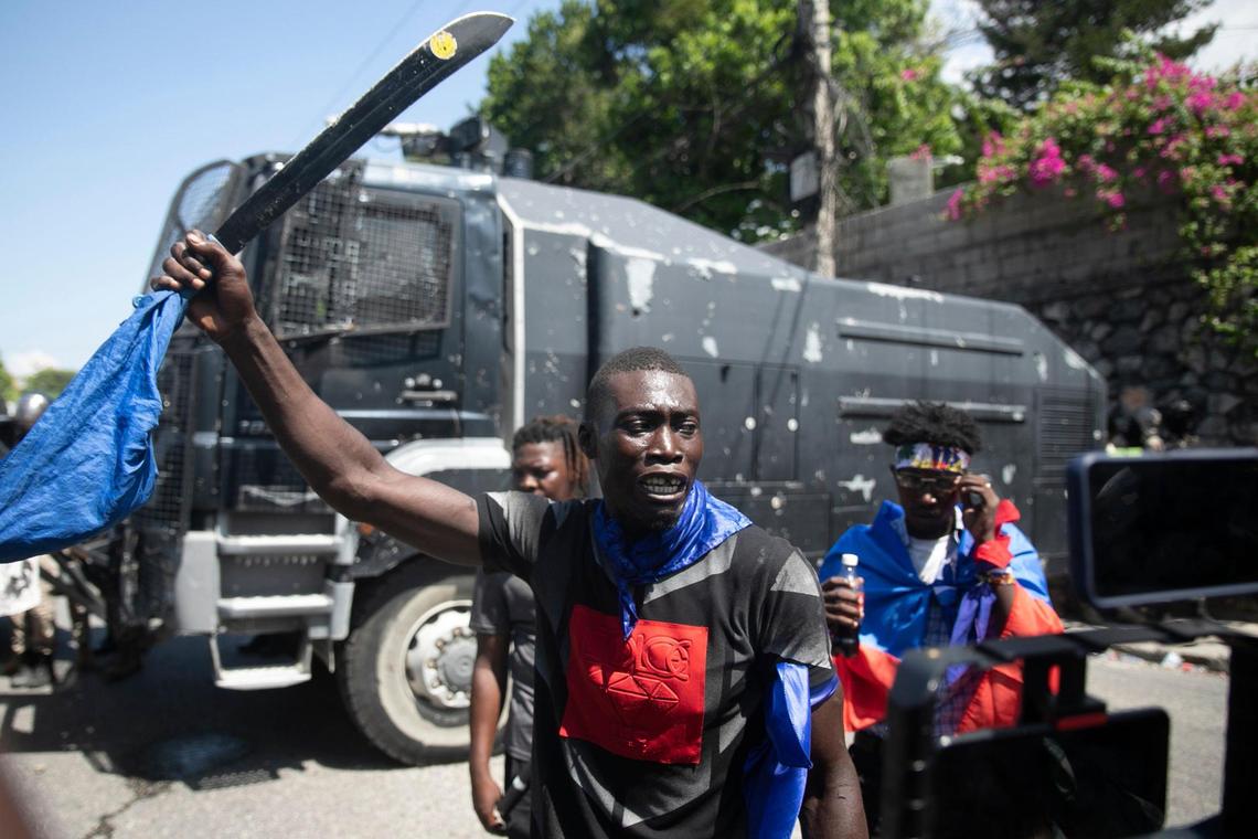 A man holds up a machete on Sept. 7, 2022, in Port-au-Prince during a protest to demand that Haitian Prime Minister Ariel Henry step down.