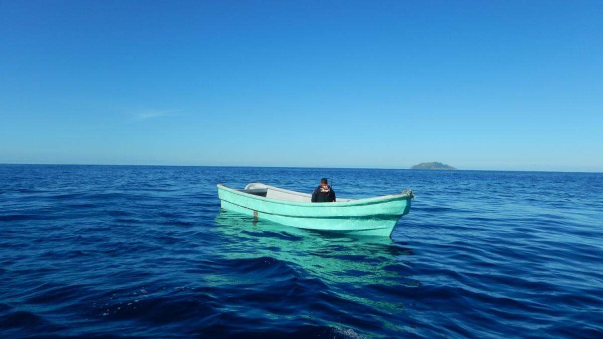 A crewmember of the Coast Guard Cutter Joseph Napier checks out the 25-foot boat on which the crew found 13 adults.