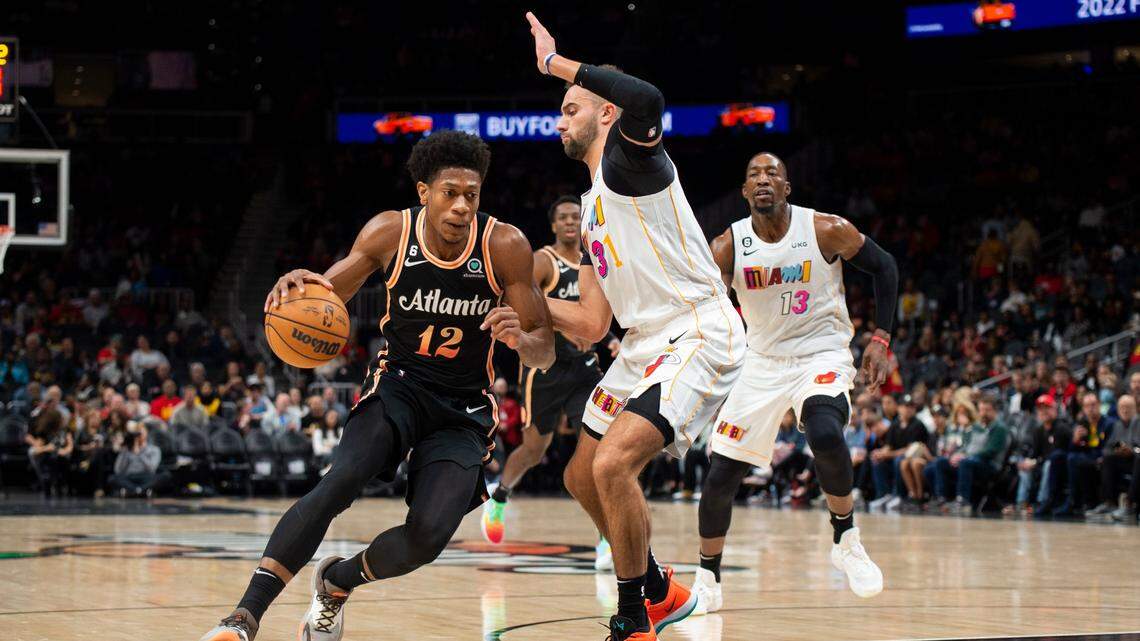 Atlanta Hawks forward De’Andre Hunter dribbles against Miami Heat guard Max Strus during the first half of an NBA basketball game, Sunday, Nov. 27, 2022, in Atlanta.