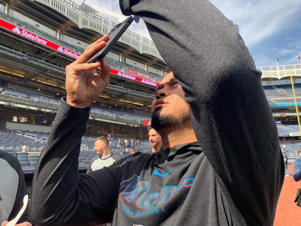 El segunda base de los Marlins Luis Arráez toma una foto del eclipse solar en el Yankee Stadium en Nueva York, el 8 de abril de 2024.