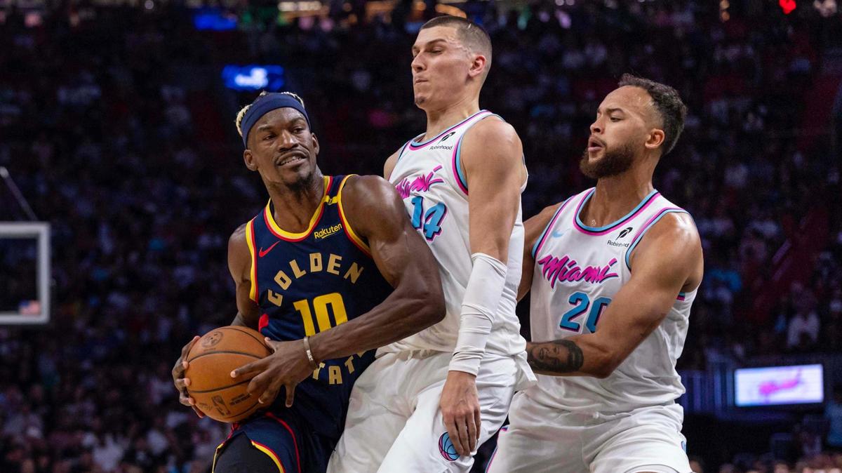 Golden State Warriors forward Jimmy Butler III (10) drives down the lane into the paint while defended by Miami Heat guard Tyler Herro (14) and forward Kyle Anderson (20) during the first half of an NBA game at Kaseya Center on Tuesday, March 25, 2025, in Miami, Florida.