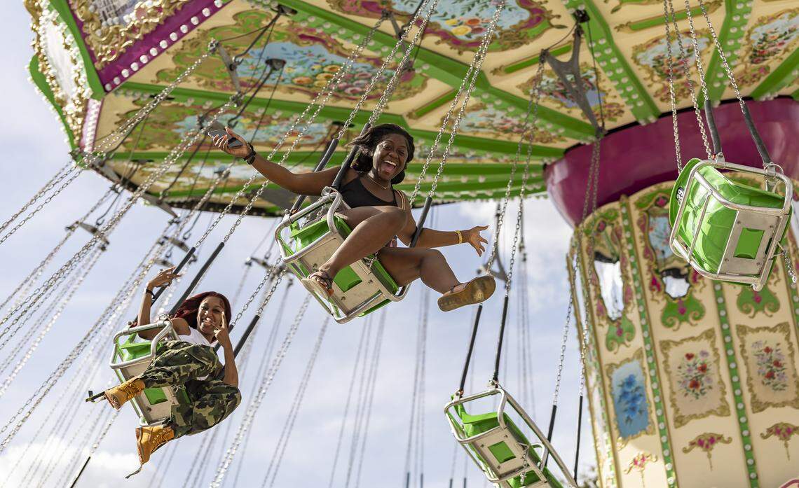 Abigail Sculley, center, and Rakale McCormick react as they ride a swing attraction during the opening day of the 74th annual Miami-Dade County Youth Fair on Thursday, March 12, 2026, in Miami, Fla.