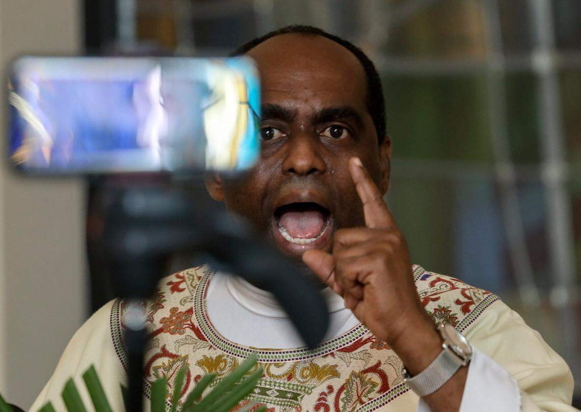 In this April 12, 2020, file photo, Rev. Reginald Jean-Mary holds Mass inside the small chapel at Notre Dame d’Haiti Catholic Church in Miami, Florida, as houses of worship closed their doors and livestreamed their Easter Sunday Masses via social media. Large social and religious gatherings were prohibited due to shelter-in-place mandates by local and state governments during the COVID-19 pandemic.