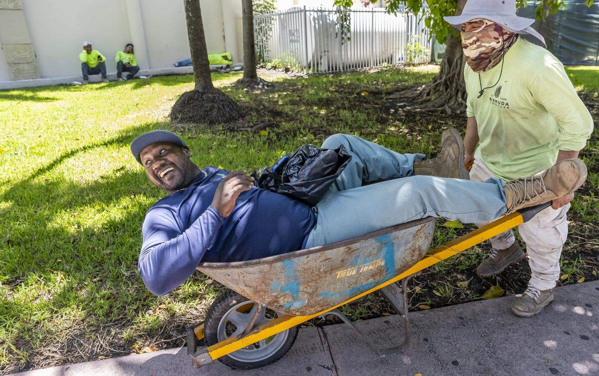 Louino Josema is pushed in a wheelbarrow by Juan De Leon near South Pointe Park as hot weather moves through the area on Friday, Aug. 15, 2025, in Miami Beach, Fla. Forecasters have issued heat advisories throughout the summer in South Florida, with temperatures at times feeling as hot as 109 degrees.