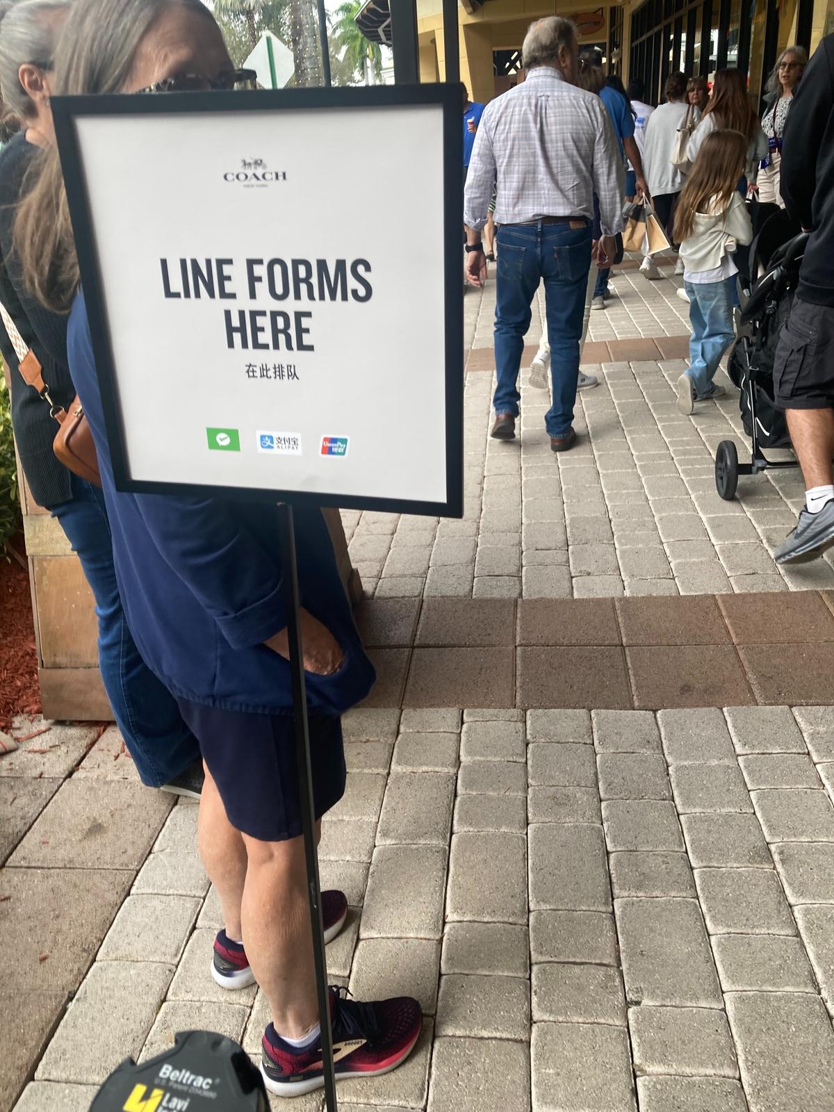 A sign keeps people in line at the Coach store at Sawgrass Mills on Black Friday, 2025.