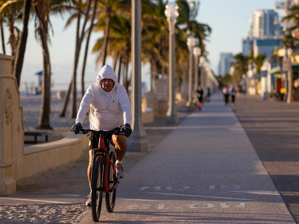Un ciclista recorre el paseo marítimo de Hollywood Beach mientras las temperaturas alcanzan los 40 grados el sábado 14 de enero de 2023, en Hollywood, Florida.