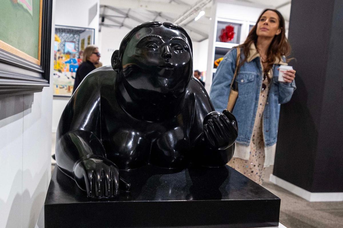A young lady walks past a sculpture created by Fernando Botero during Art Miami at One Herald Plaza on Tuesday, Dec. 3, 2024, in Miami, Fla.
