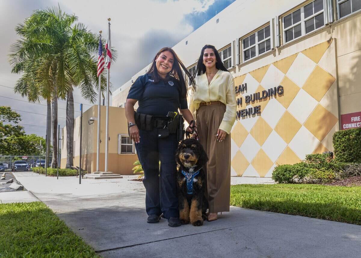 La concejal de la ciudad de Hialeah, Gelien Pérez, posa con la oficial Lucicarmen López y Dominó, el perro de terapia oficial de la Policía de Hialeah, en la sede policial de Hialeah, el martes 16 de junio de 2026.