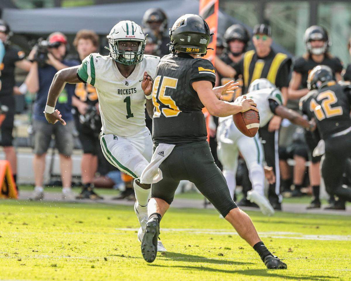 Miami Central High School line backer Wesley Bissanthe (1) chases Merritt Island High School quarterback Brady Denaburg (15) in the first half during the FHSAA Class 5A State Championship at DRV PNK Stadium, in Fort Lauderdale on Friday, December 17, 2021. 