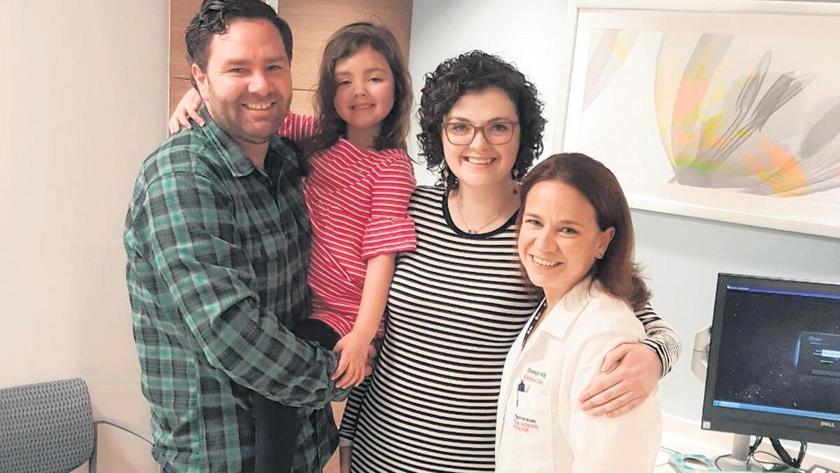 Brittany Sullivan on the last day of treatment in February Sylvester Comprehensive Cancer Center at the University of Miami Miller School of Medicine. From left, Brittany’s husband, John Sullivan, their daughter Carley Jean, Brittany and Dr. Breelyn Wilky, medical oncologist at Sylvester. Brittany was treated with immunotherapy in a clinical trial at Sylvester, which shrunk her tumors significantly.