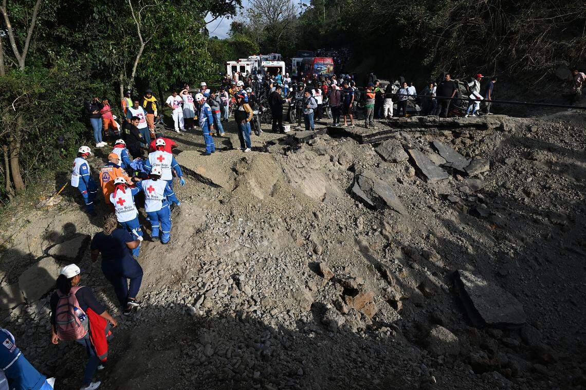 Trabajadores de la Cruz Roja operan en el lugar de una explosión, mientras la gente observa, tras un atentado con bomba en El Túnel —en la carretera Popayán-Cali— en Cajibío, departamento del Cauca, Colombia, el 25 de abril de 2026.