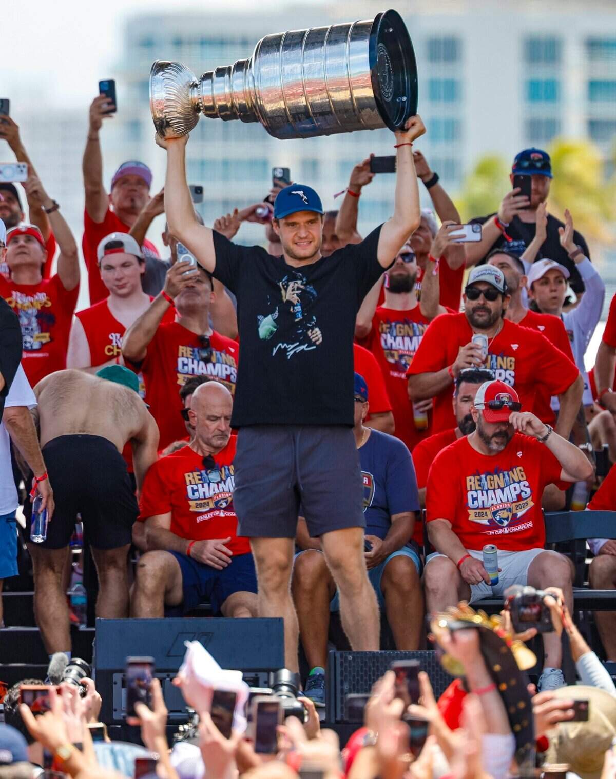 Florida Panthers center Aleksander Barkov hoists the Stanley Cup as teammates celebrate on stage during the team’s victory parade and rally along A1A in Fort Lauderdale, Florida, on Sunday, June 22, 2025