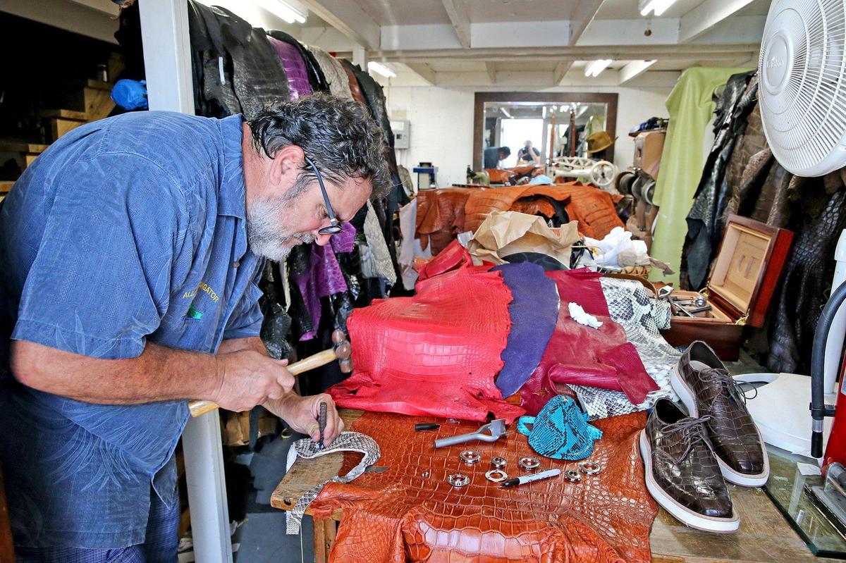 Brian Wood works on a mask made from an invasive Florida python snake in his workshop in Dania, Florida, April 8, 2020. He is developing protective masks made with python, alligator and other skins as the coronavirus outbreak has made medical mask part of our daily routine recently.