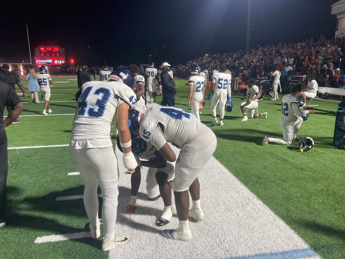 Miami Palmetto football players console each other on the sideline after losing 45-44 in overtime to Vero Beach in a Class 7A state semifinal on Friday, Dec. 5, 2025 at Vero Beach High School.