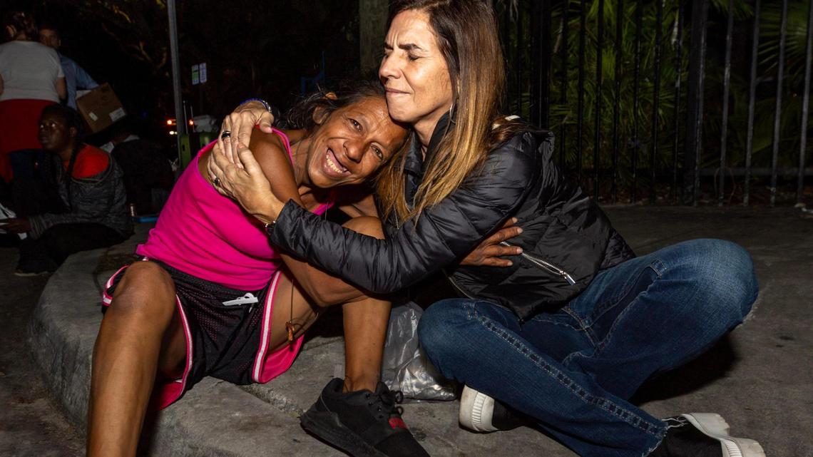 Hermanos de la Calle volunteer Susana Alvarez hugs Amaranta Gómez on NW 17th Street in Miami, Florida, on Friday, December 22, 2023. Hermanos de la Calle and members of various local congregations helped feed the unsheltered and assisted people with finding shelter.