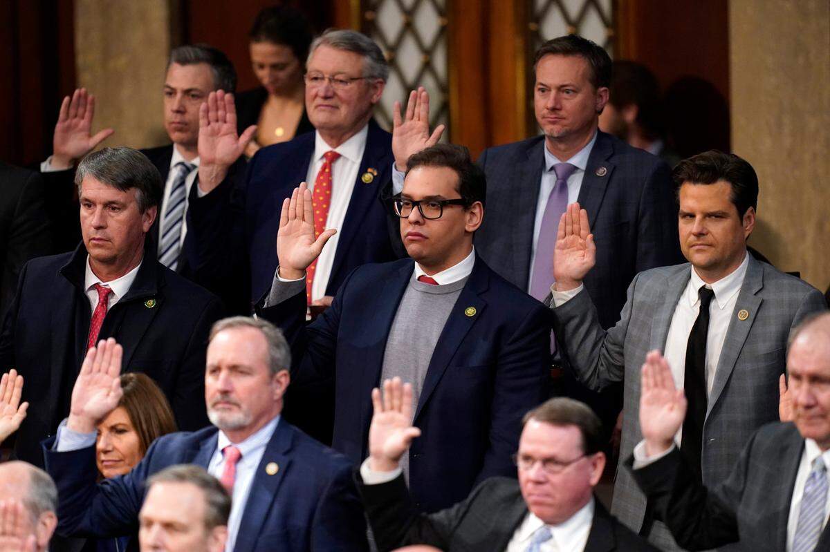 Rep. George Santos takes the oath of office. The fingers of his other hand were crossed.
