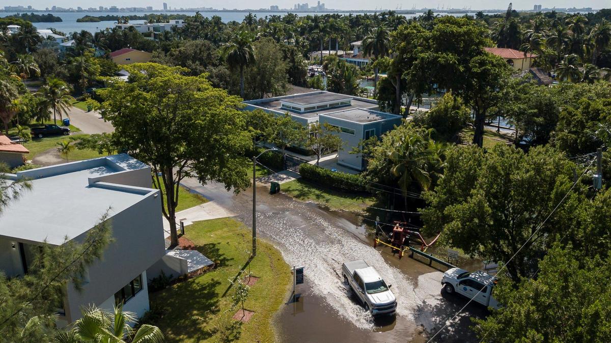 An aerial view of a vehicle making its way through a flooded street near Little River Pocket Park on Monday, Oct. 30, 2023 in Miami, Fla. Monday was the highest king tide of the year for South Florida, flooding streets, driveways and parks. Flooding from king tides will become more frequent as the sea level rises.