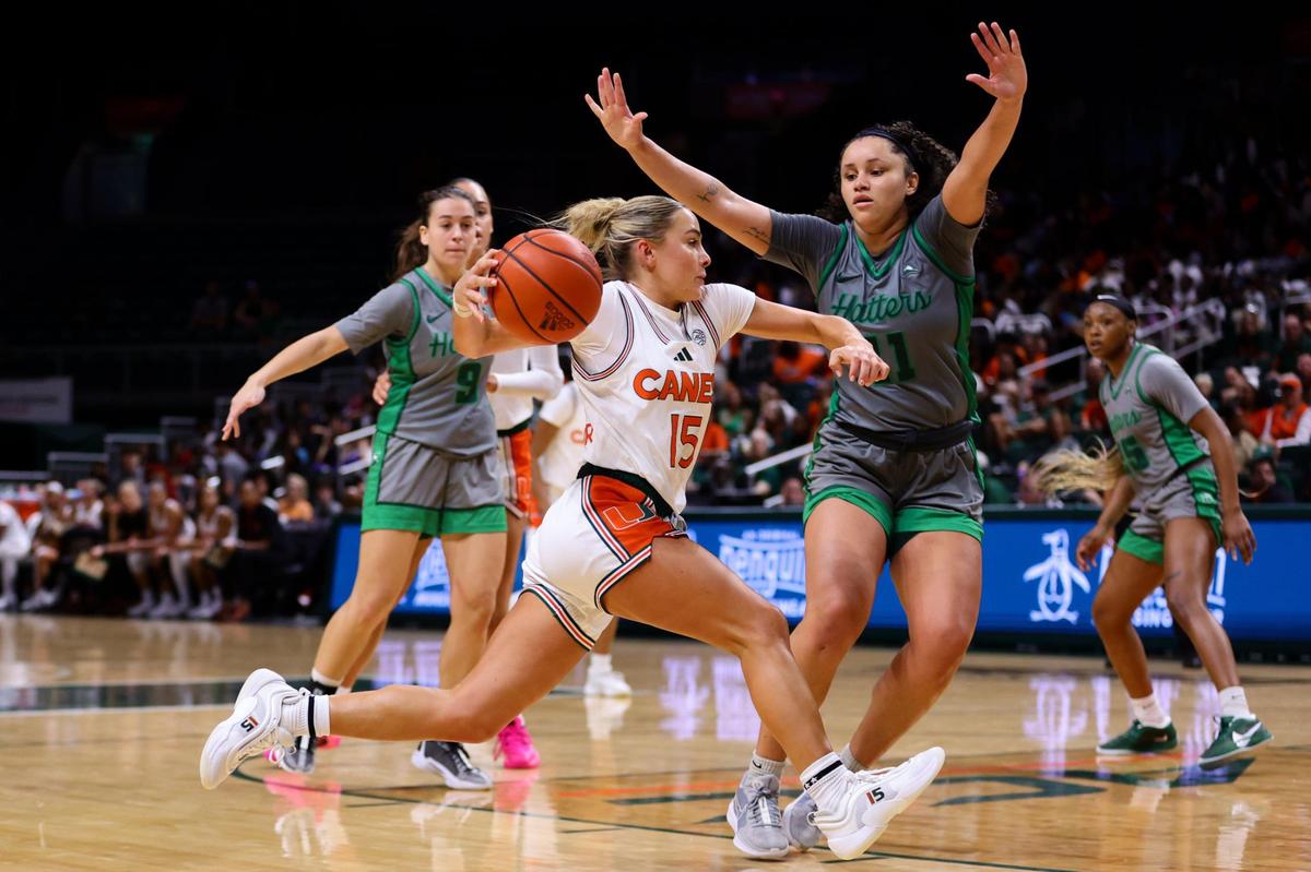 Miami Hurricanes guard Hanna Cavinder (15) drives to the basket against Stetson Hatters forward Tiasia McMillan (11) during the second quarter at the Watsco Center in Coral Gables, Florida, Monday, November 4, 2024.