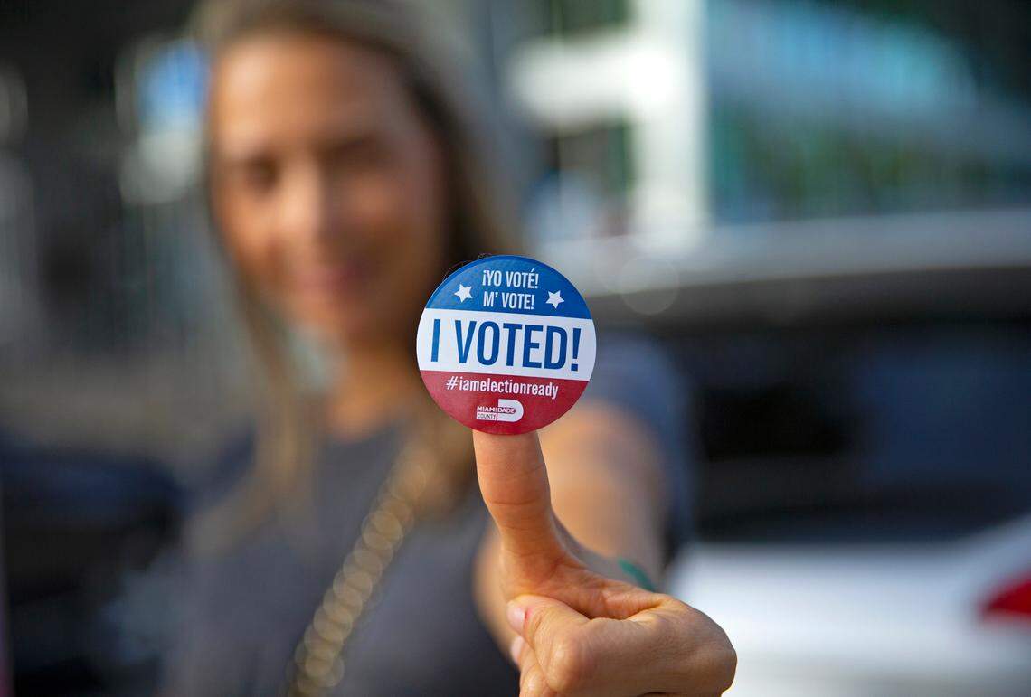 Sucel Peleg poses with her vote sticker after casting her vote during early voting for the general election at Northeast Dade–Aventura Branch Library on Wednesday, October 28, 2020, in Aventura. The general election is Tuesday, Nov. 3.