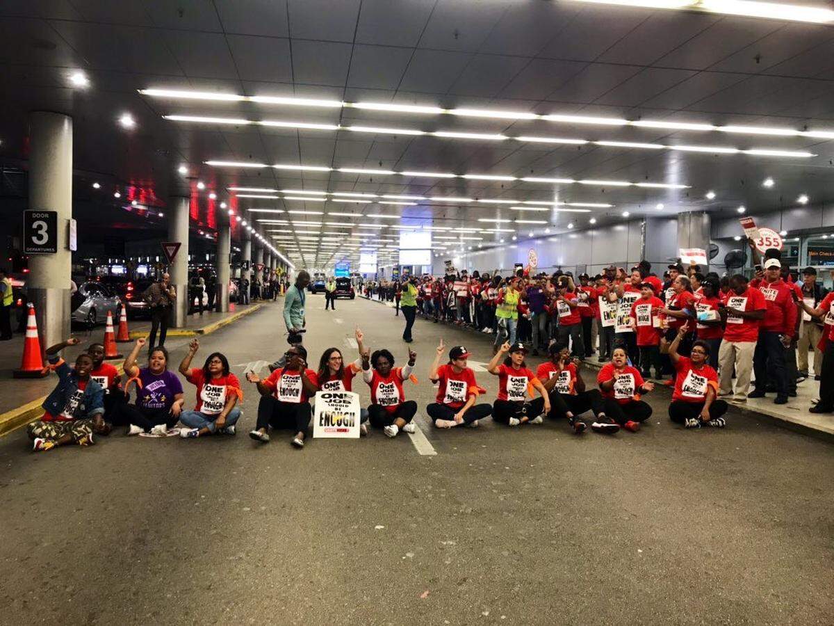 Twelve Sky Chefs workers and their union representatives block the Arrivals road in front of Terminal D at Miami International Airport on Tuesday, November, 26, 2019.