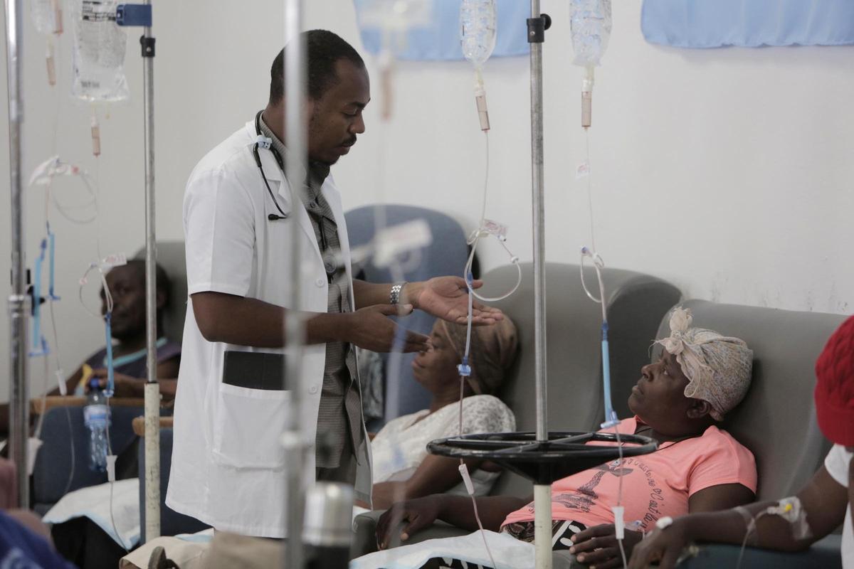 Un médecin parle à Paula Paul, 44 ans, alors qu’elle s’hydrate avant de recevoir une chimiothérapie palliative à l’Hôpital Universitaire de Mirebalais, au centre d’Haïti.