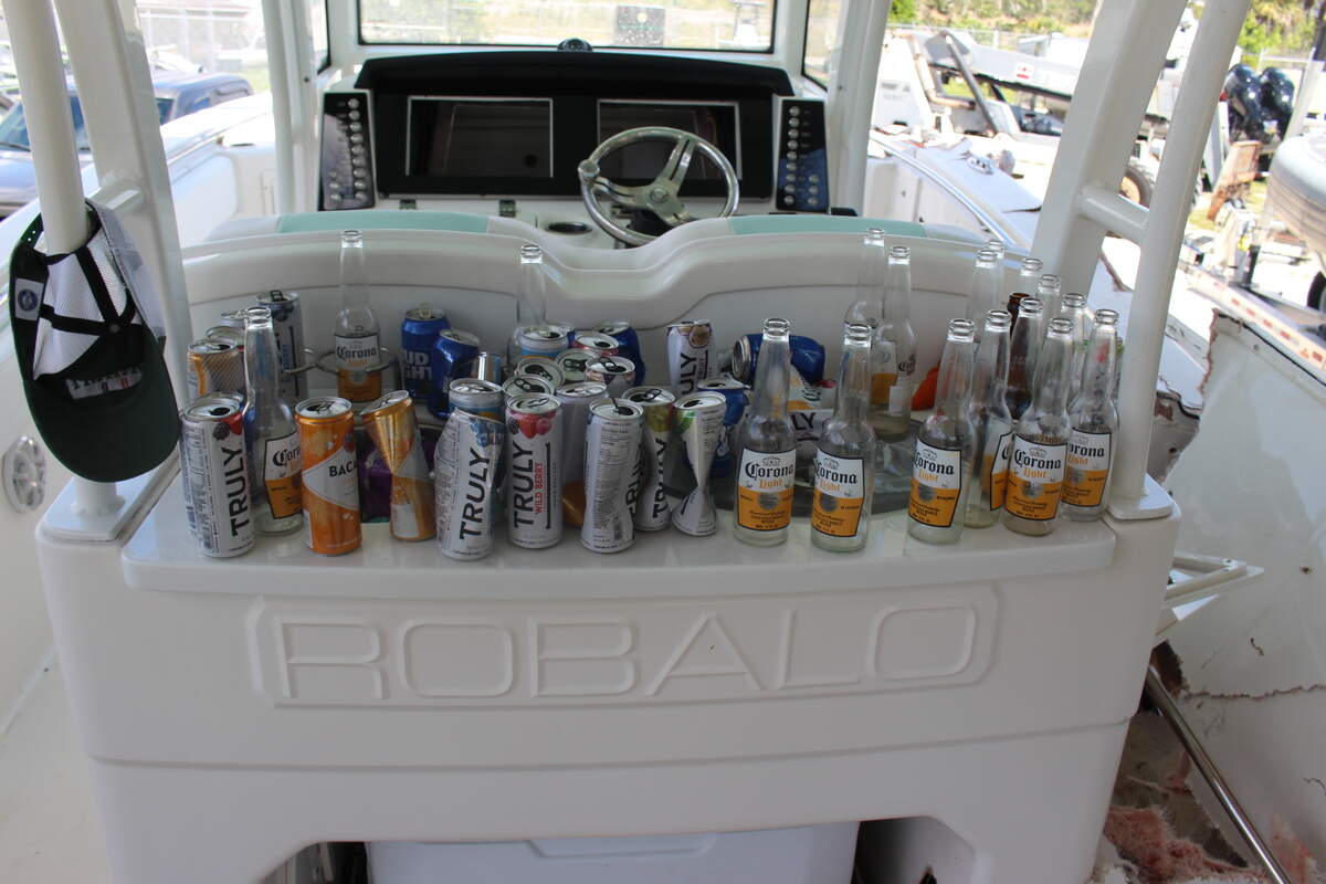 Empty beer and other alcoholic beverage bottles and cans are lined up behind the cockpit of George Pino’s 29-foot Robalo boat on Sept. 5, 2022.