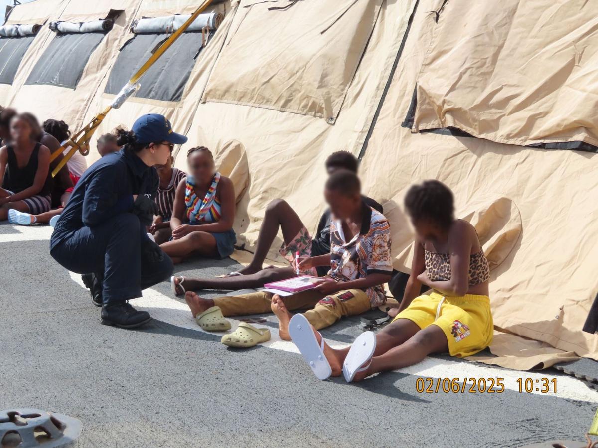 A U.S. Coast Guard member speaks with a group of people from Haiti who were stopped on an overloaded migrant sailboat Tuesday, Feb. 4, 2025.