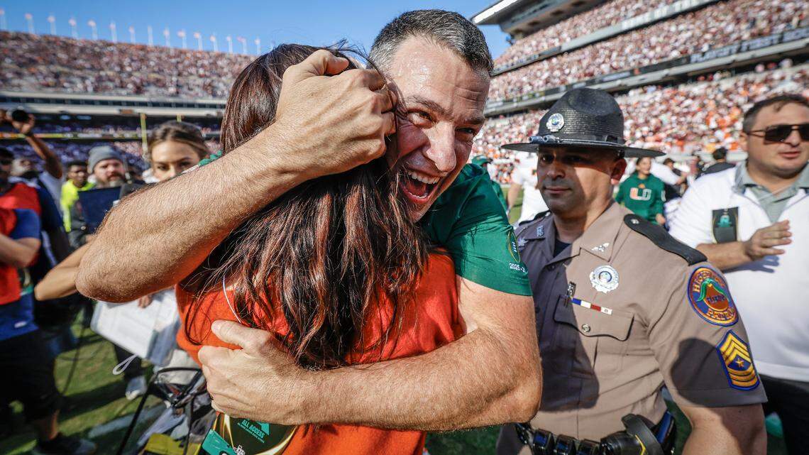 Miami Hurricanes head coach Mario Cristobal hugs his wife Jessica as he leaves the field after the Canes defeat Texas A&M Aggies 10-3 in the first round of the 2025 College Football Playoff at Kyle Field at College Station, Texas, on Saturday, December 20, 2025.