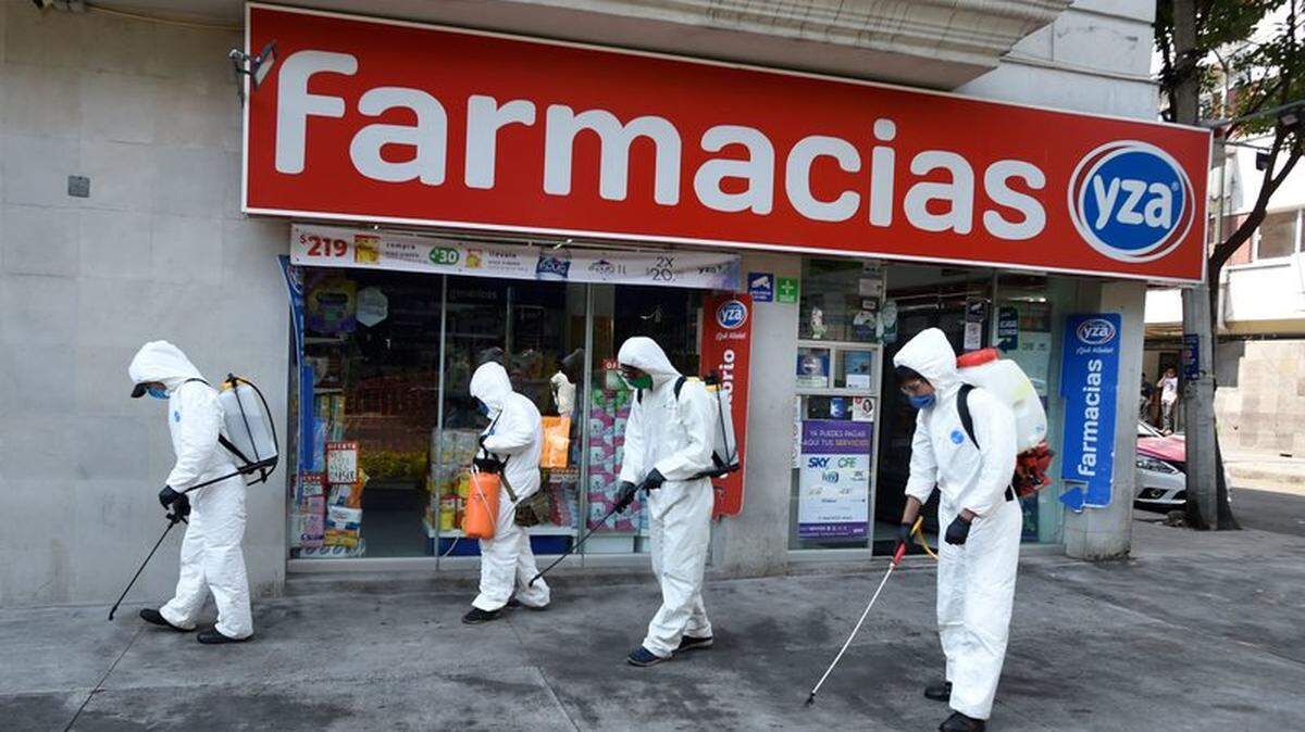Workers wearing personal protective equipment disinfect a street in Mexico City amid the COVID-19 outbreak.