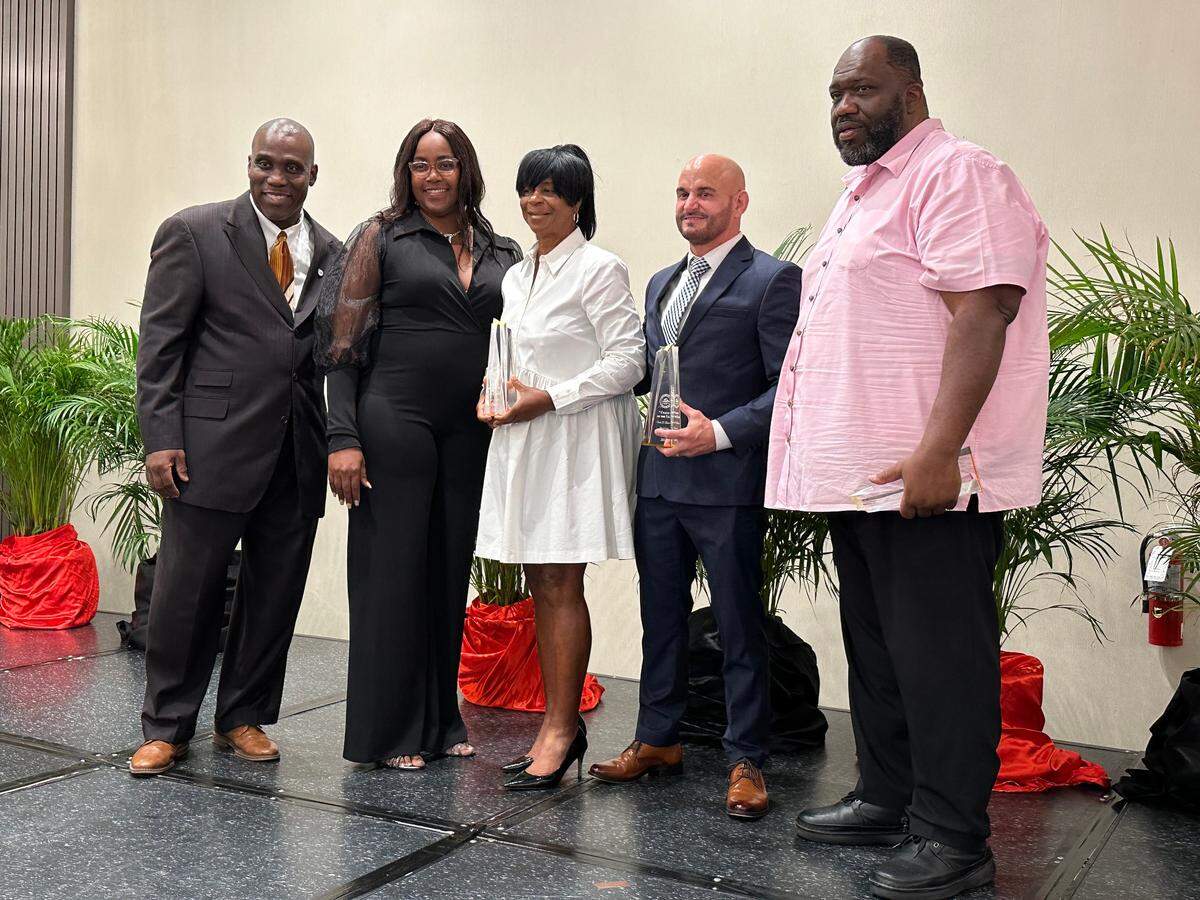 From right to left: Miami Norland basketball coach Lawton Williams, South Dade wrestling coach Vic Balmeceda and Miami Northwestern girls track and field coach Carmen Jackson were all honored Tuesday at the annual Miami-Dade County Public Schools Scholar-Athlete Awards Ceremony at the Doubletree by Hilton Miami Airport Convention Center Hotel. Standing to their left are GMAC Executive Secretary Latoya Williams and MDCPS Administrative Director Ronald Redmon.