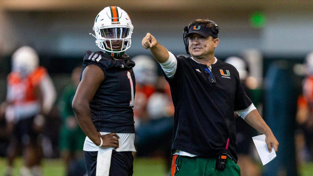 Miami Hurricanes quarterback Cam Ward (1) takes direction from Offensive Coordinator / Quarterbacks Coach Shannon Dawson looks on at the Carol Soffer Indoor Practice Facility on Wednesday, July 31, 2024, in Coral Gables, Fla.