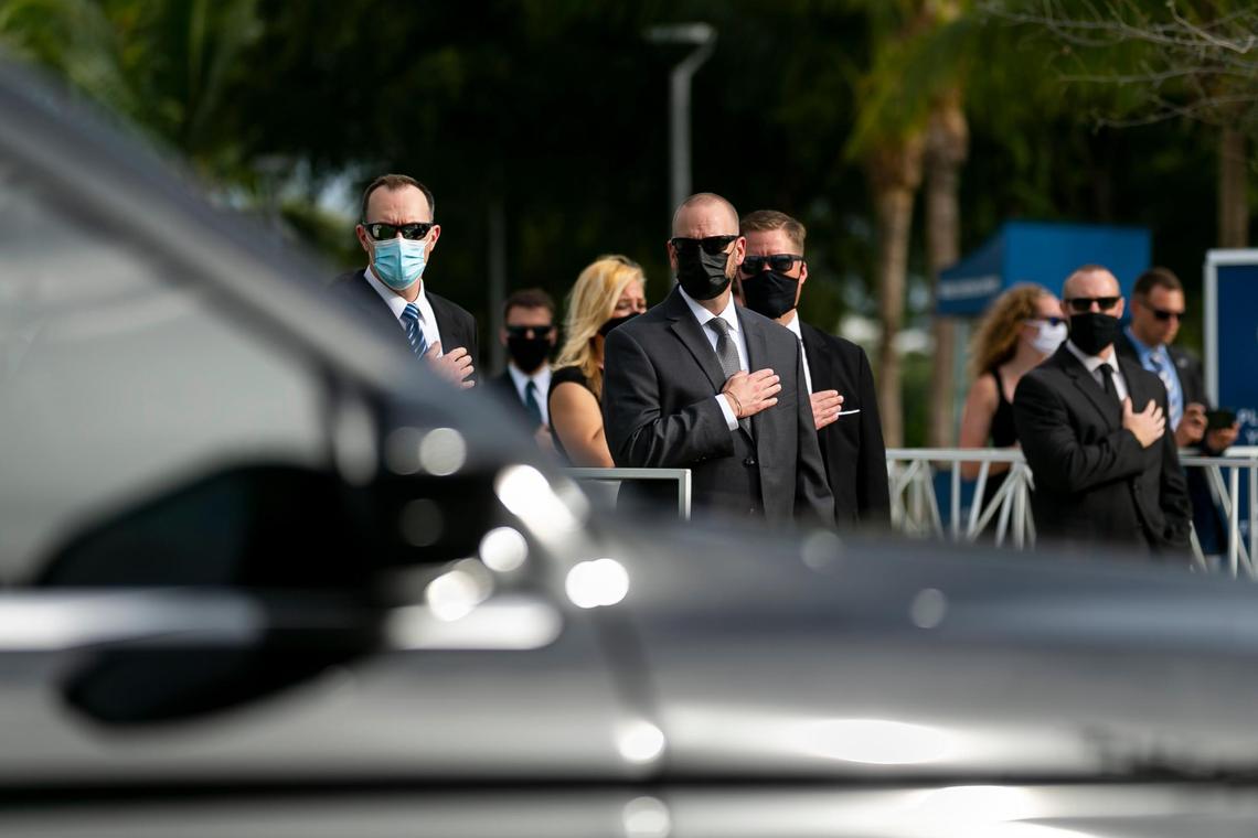 Mourners salute a motorcade departing with slain FBI agent Daniel Alfin after a memorial service in his honor was held at Hard Rock Stadium on Sunday, February 7, 2021 in Miami Gardens, Florida. Alfin is one of two FBI agents killed while serving a search warrant at a home on Tuesday in Sunrise, Florida.
