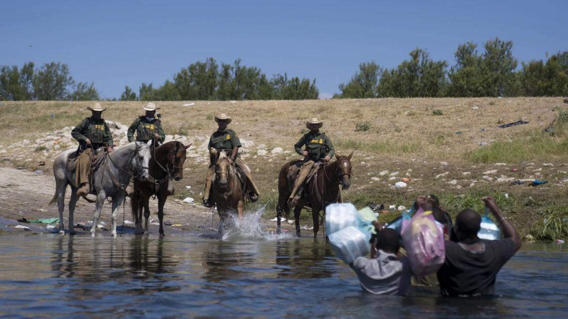Mounted U.S. Border Patrol agents stop Haitian migrants crossing the Rio Grande in Del Rio, Texas, on Sunday.