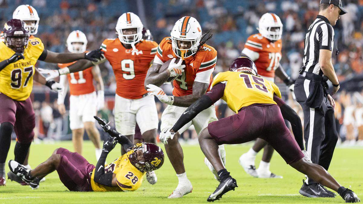Miami Hurricanes running back Mark Fletcher Jr. (4) runs with the ball as Bethune-Cookman Wildcats safety Antwone Watts (15) defends in the first half of their NCAA football game at Hard Rock Stadium on Saturday, Sept. 6, 2025, in Miami Gardens, Fla.